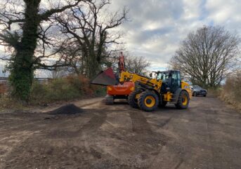 Diggers filling in potholes in the Rougham School and Church car park