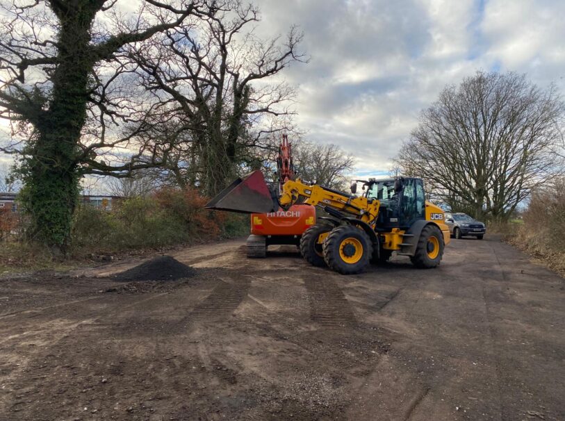 Diggers filling in potholes in the Rougham School and Church car park